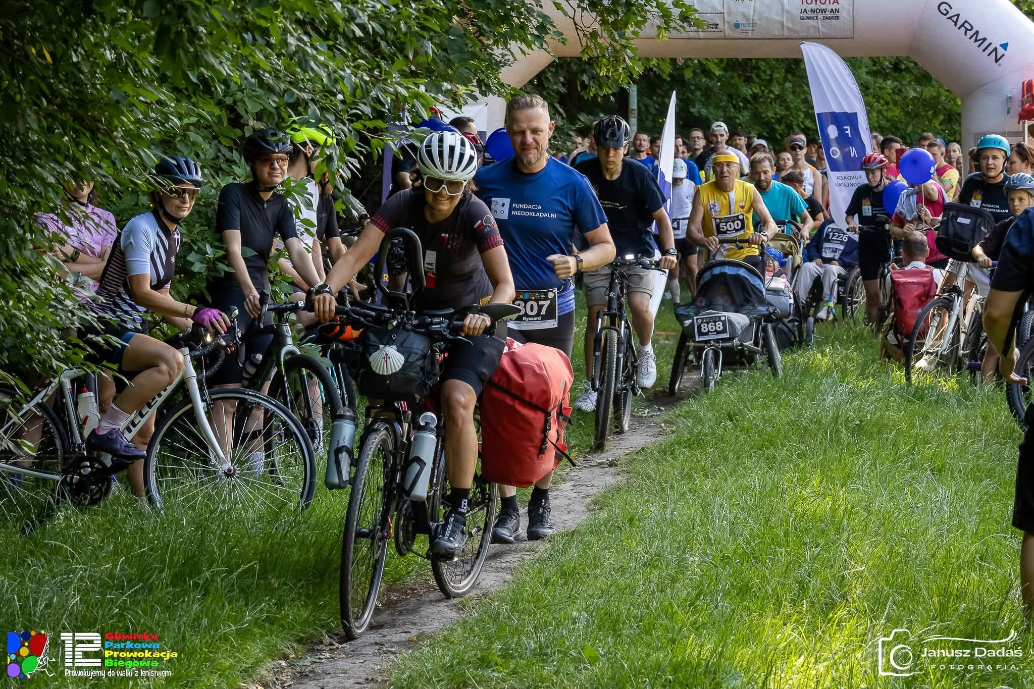 Fot. J.Dadaś Fotografia/FB Gliwickiej Parkowej Prowokacji Biegowej kobieta na rowerze, ludzie obok