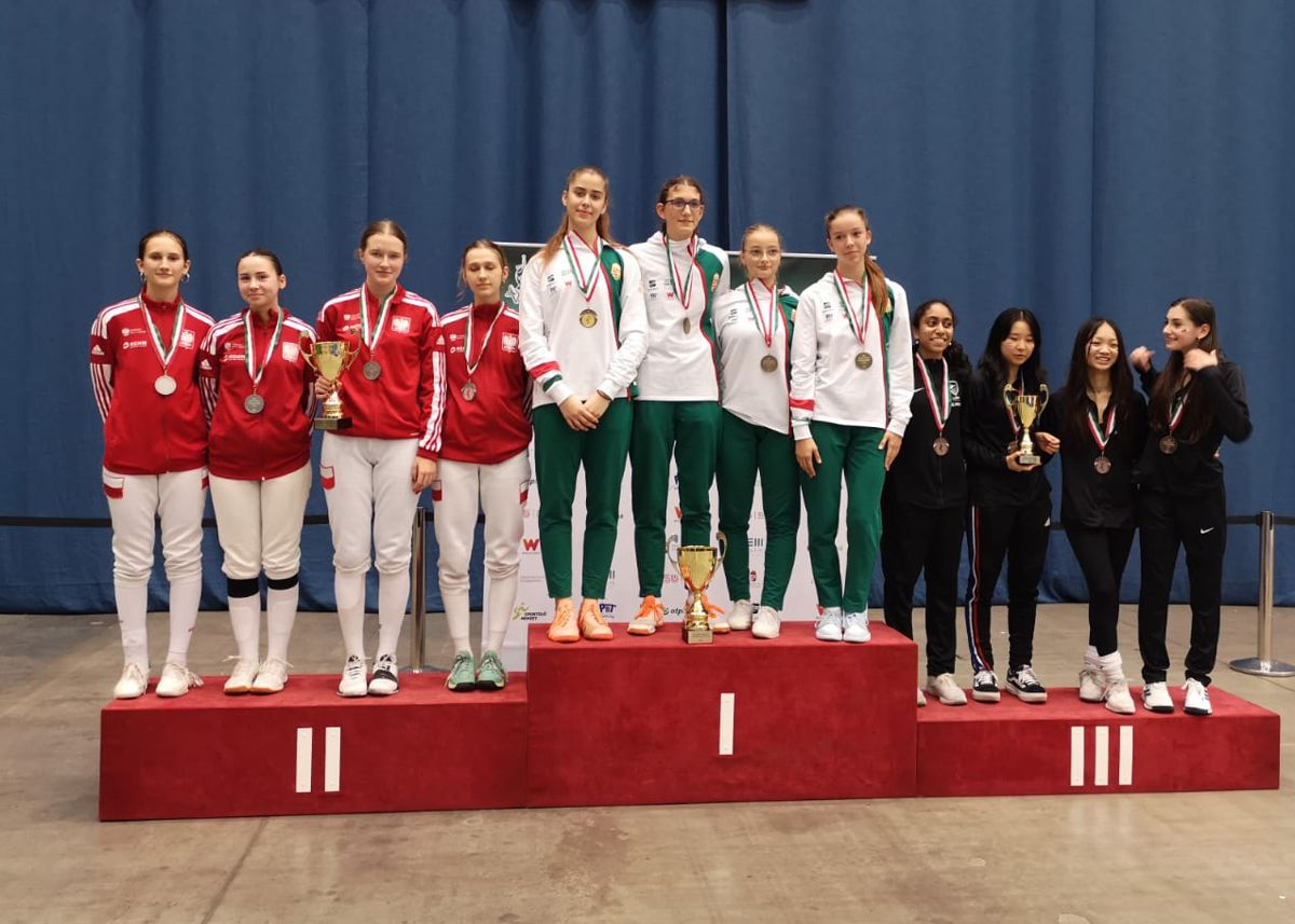 Srebrna drużyna dziewcząt stojąca na podium z drużynami, które zajęły 1. i 3. miejsce