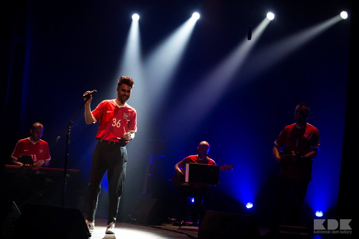 wokalista w czerwonej koszulce na scenie