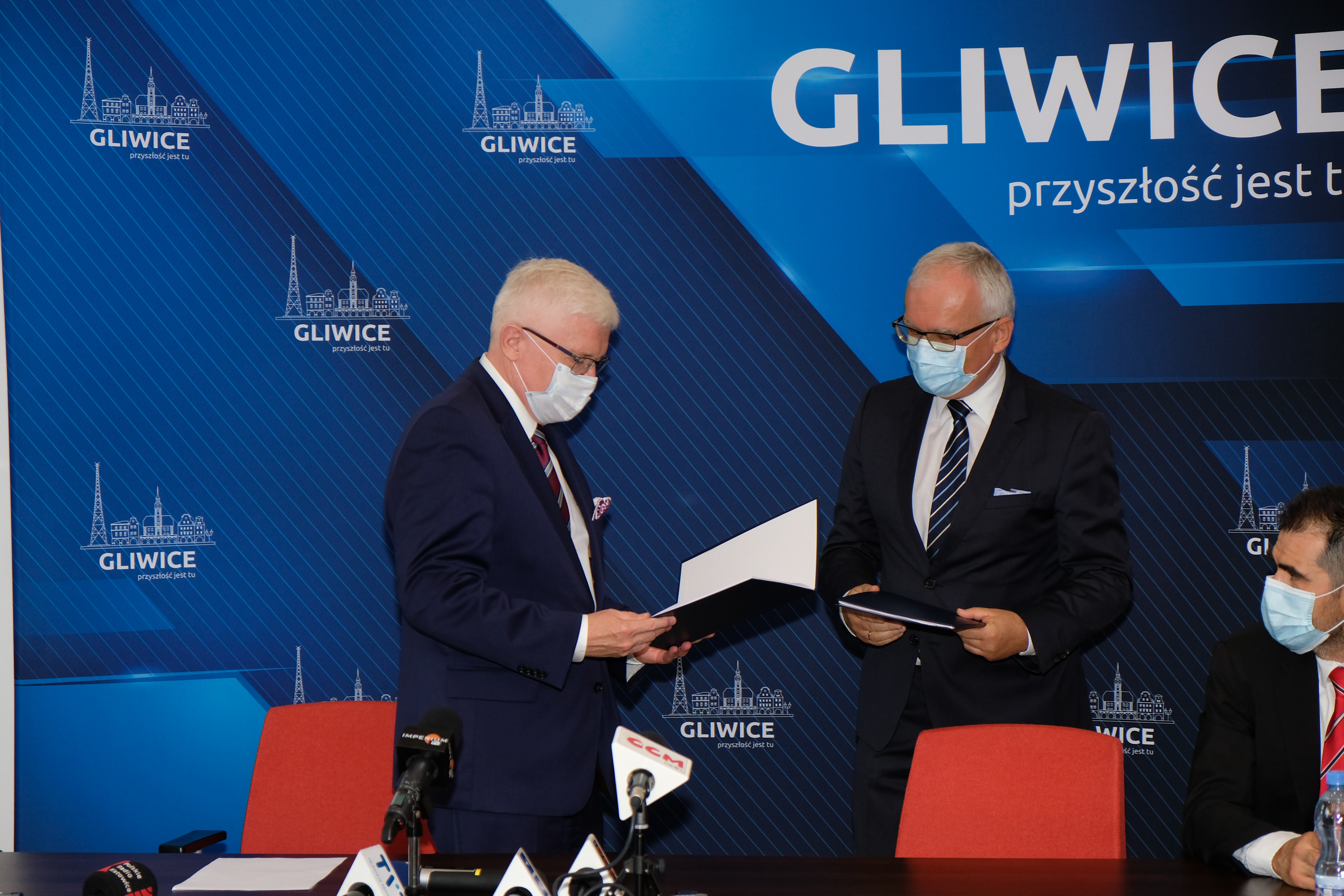 Wymiana teczek podczas konferencji prasowej