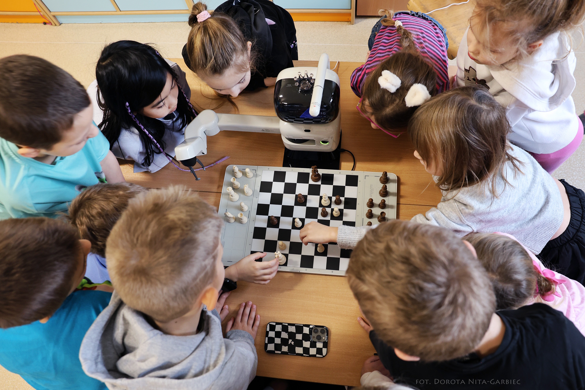 Dzieci grające w szachy z robotem