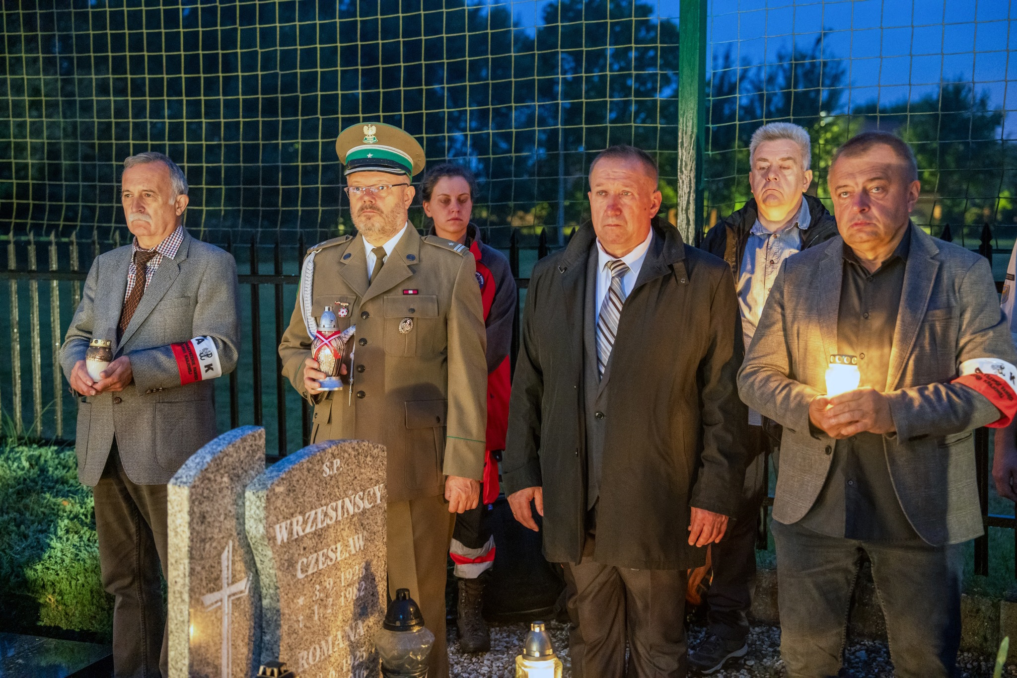 Fot. G. Ożga/UM w Gliwicach Uczestnicy obchodów stoją ze zniczami na cmentarzu