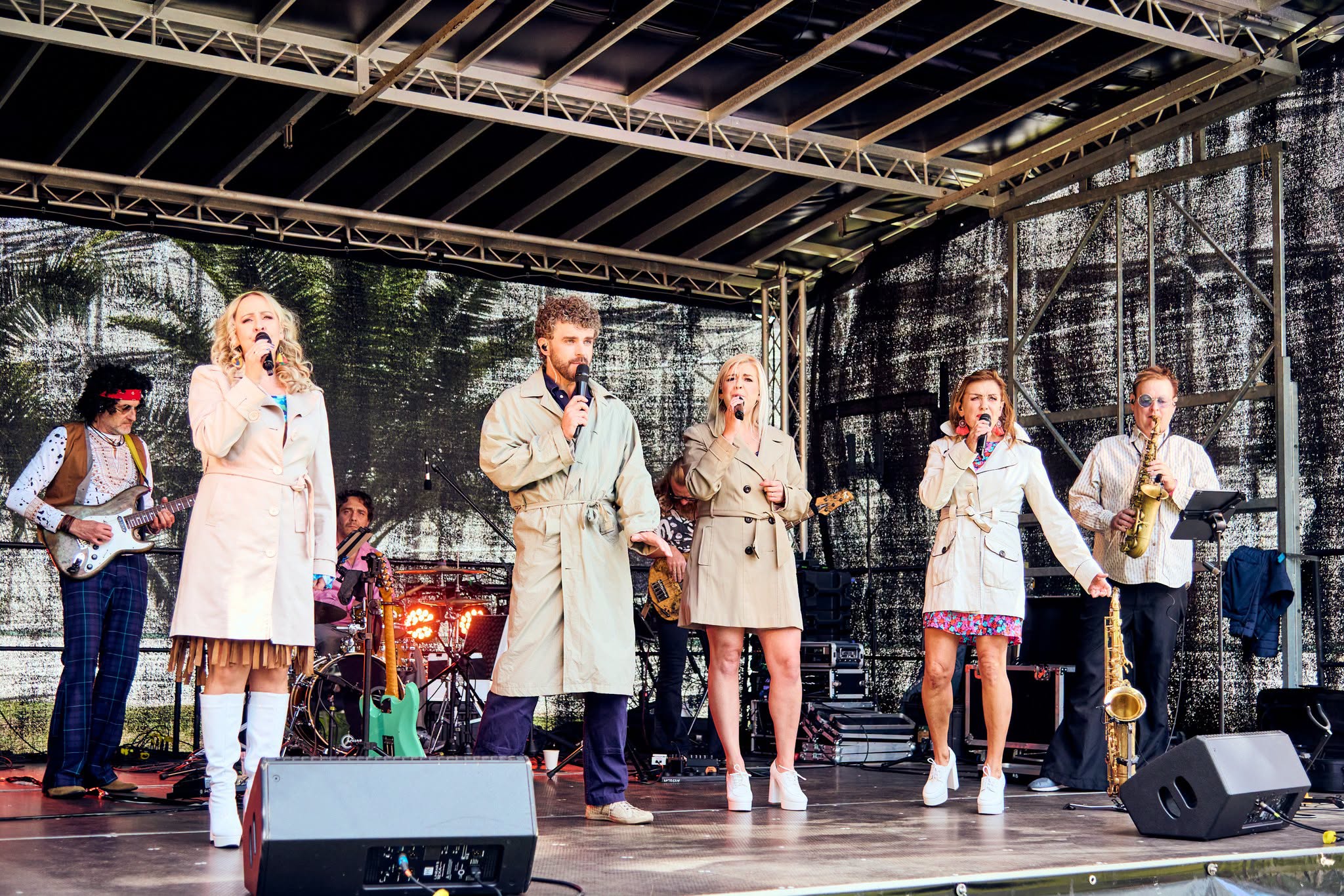 ludzie na scenie podczas występu w płaszczach