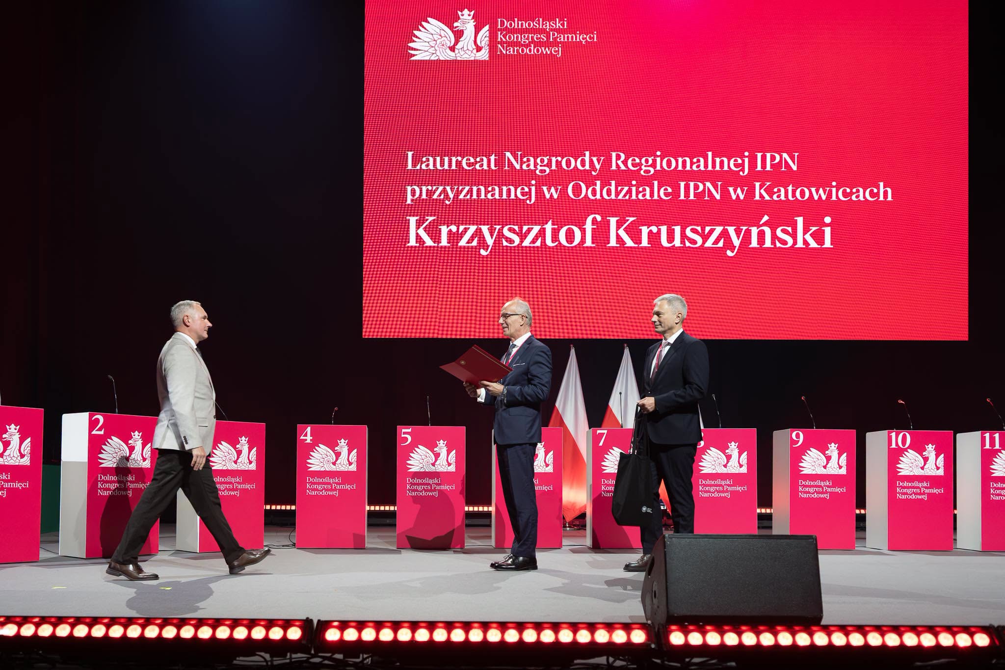 trzech mężczyzn na scenie