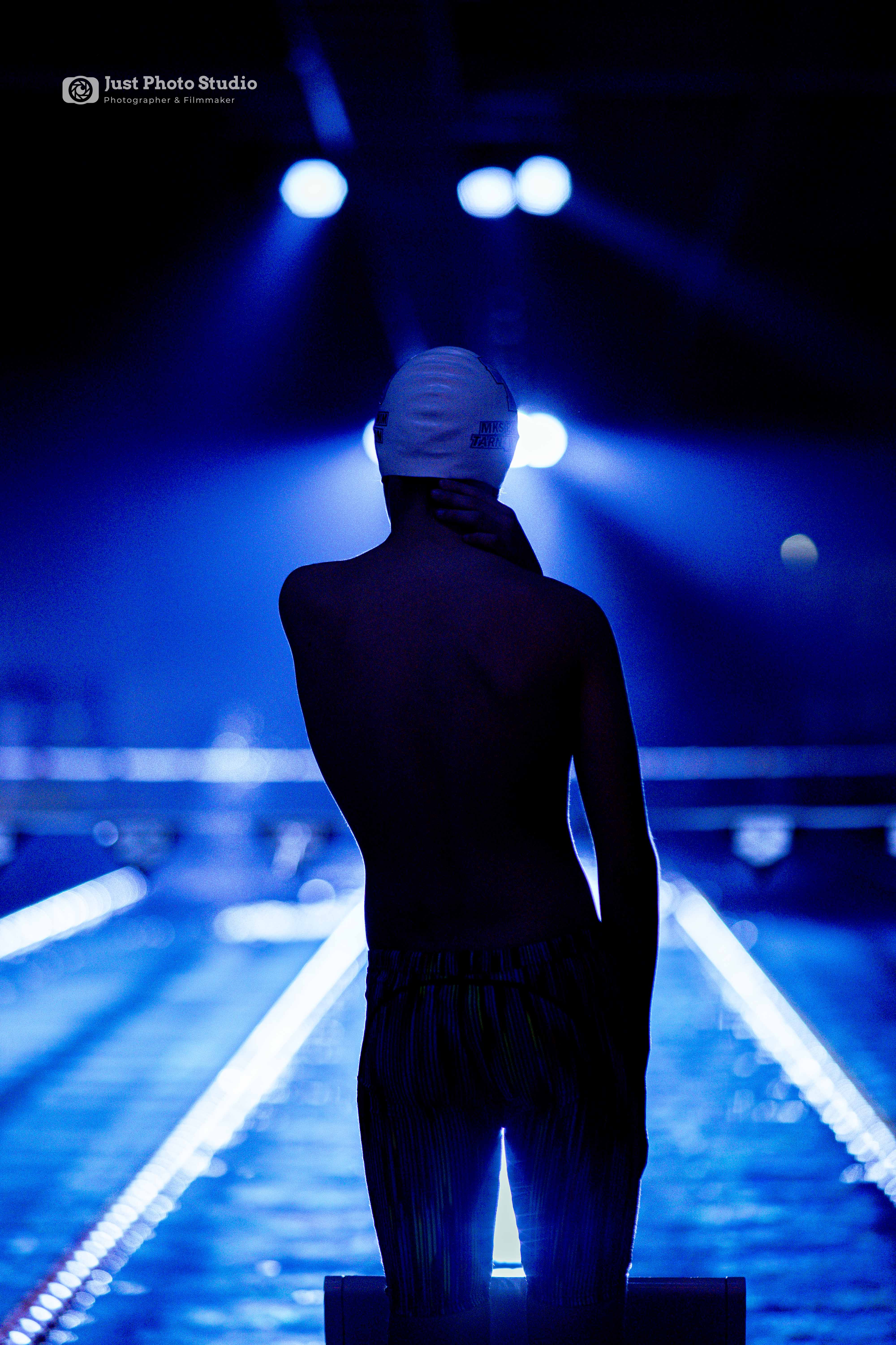 Pływak stojący w ciemności nad basenem