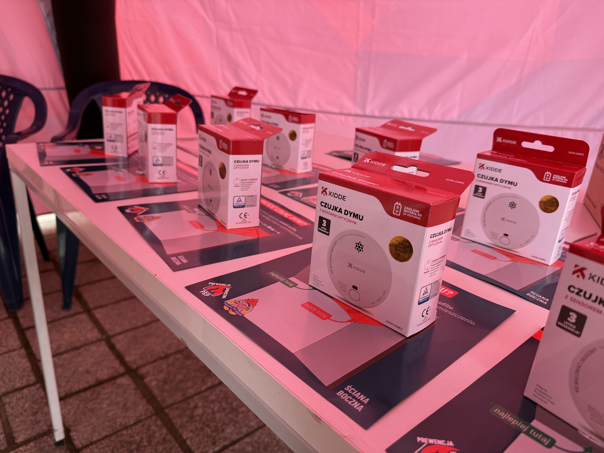 czujki dymu w pudełkach na stole