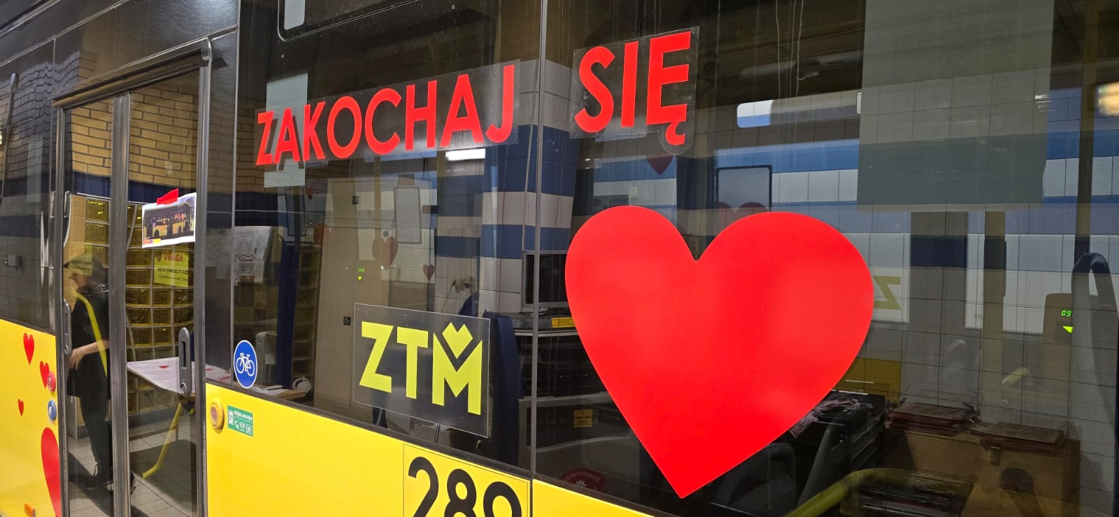 Fot. PKM Gliwice Czerwony napis Zakochaj się i czerwone serce na szybie żółtego autobusu