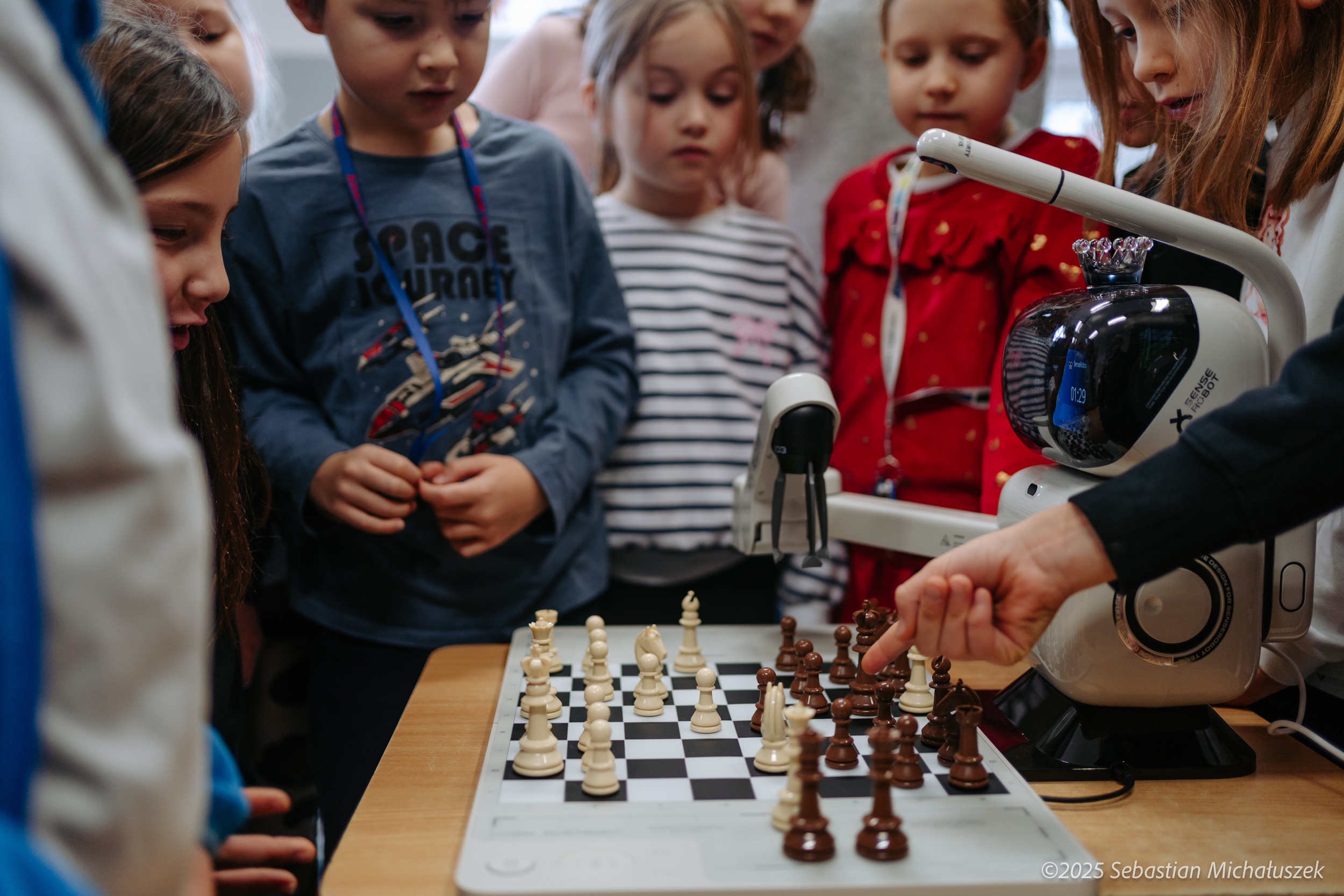 Dzieci grające w szachy z robotem