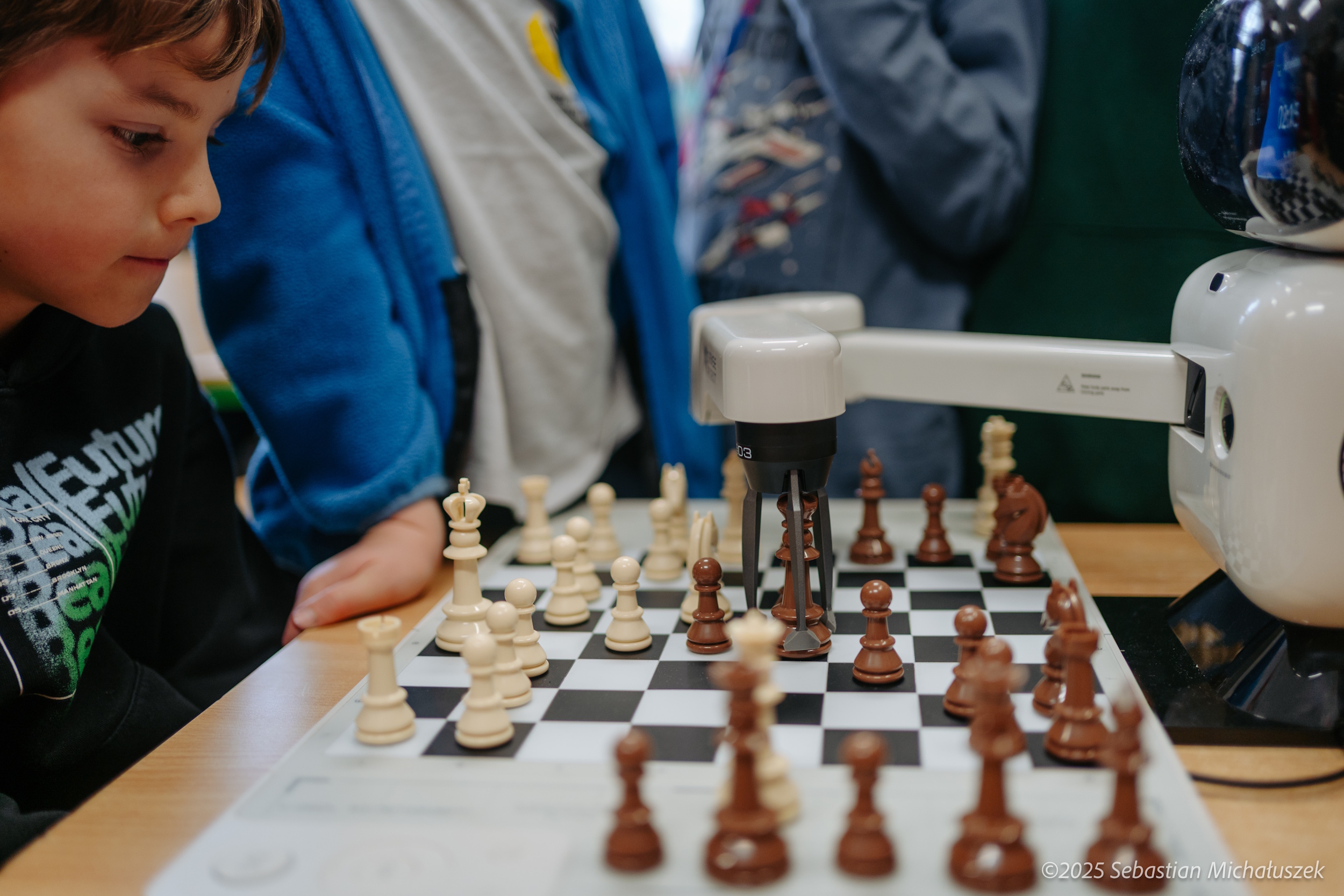 Dzieci grające w szachy z robotem