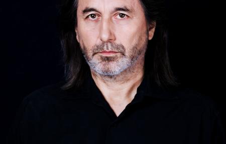 mężczyzna w długich brązowych włosach i czarnej koszuli